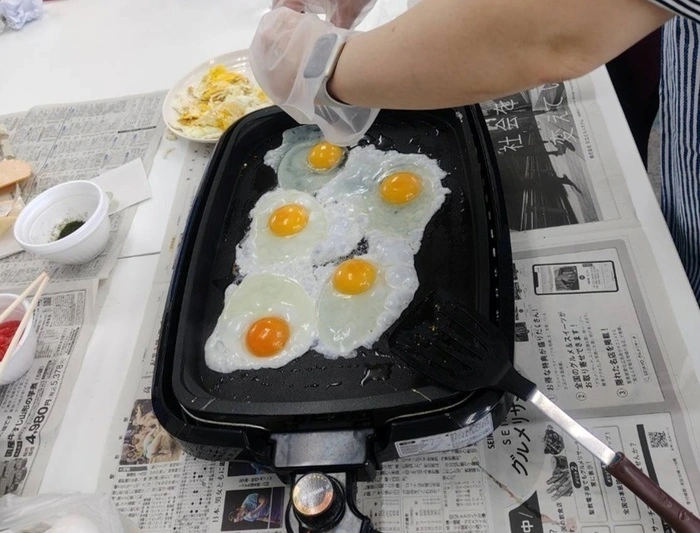 たません作りで目玉焼きを作っている様子