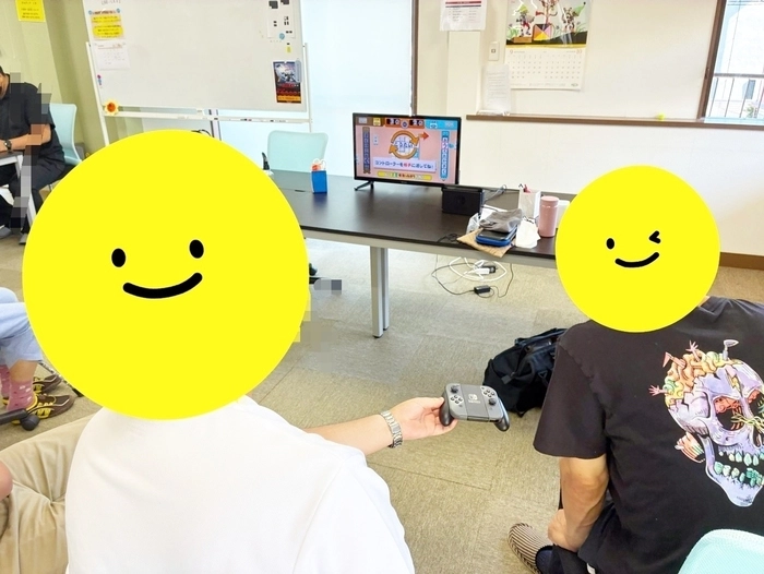 ゲームに集中している利用者さんたちの後ろから撮った写真